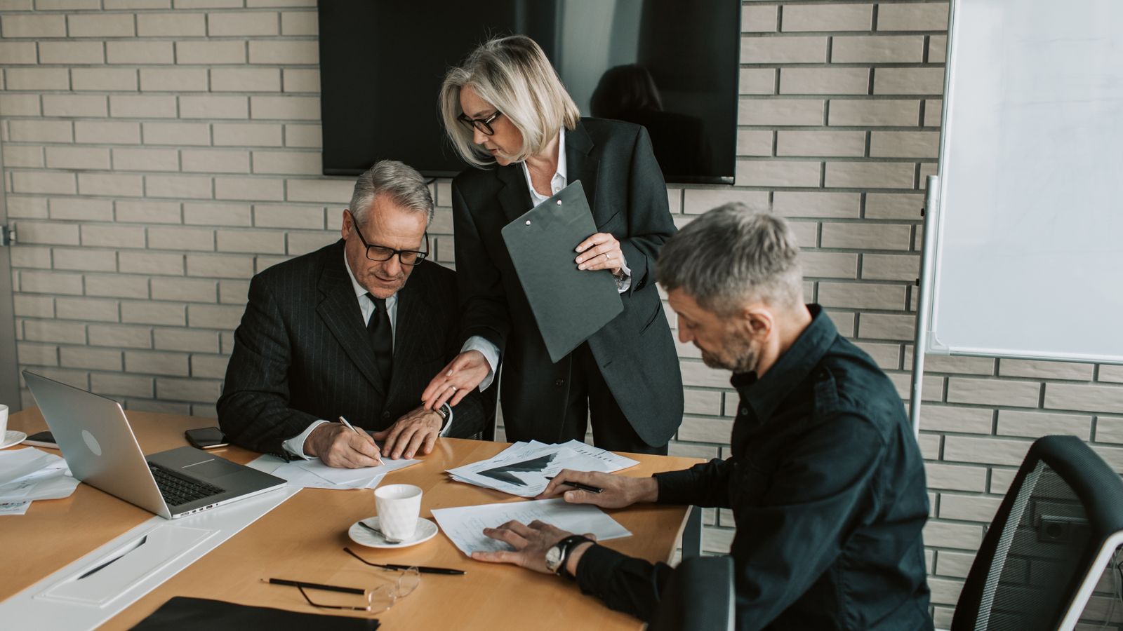 Professionals reviewing and signing business documents.