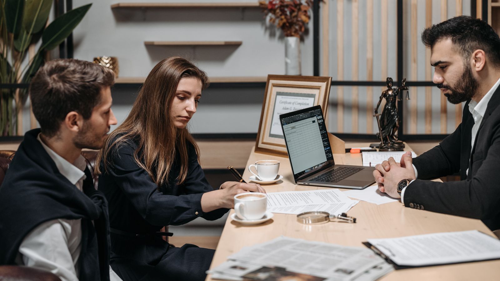 Colleagues reviewing documents around an office table.