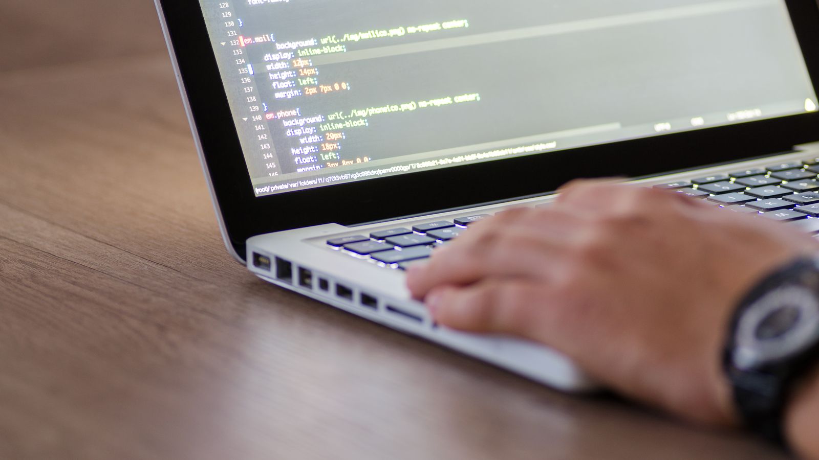 A developer working on code on a laptop.