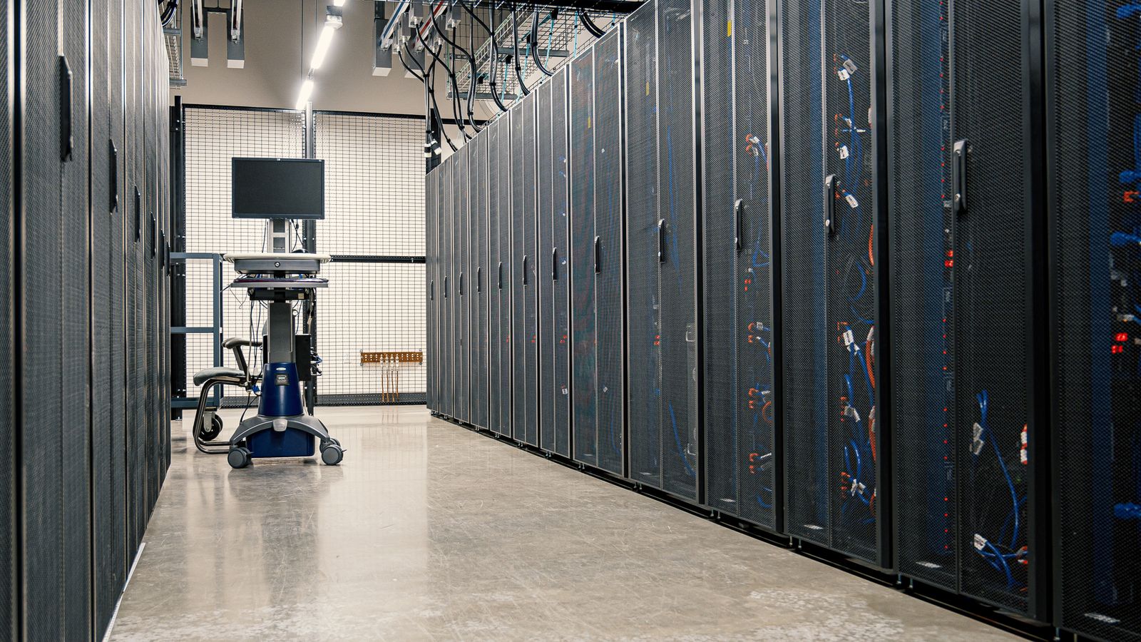 A corridor between rows of data centre server racks.