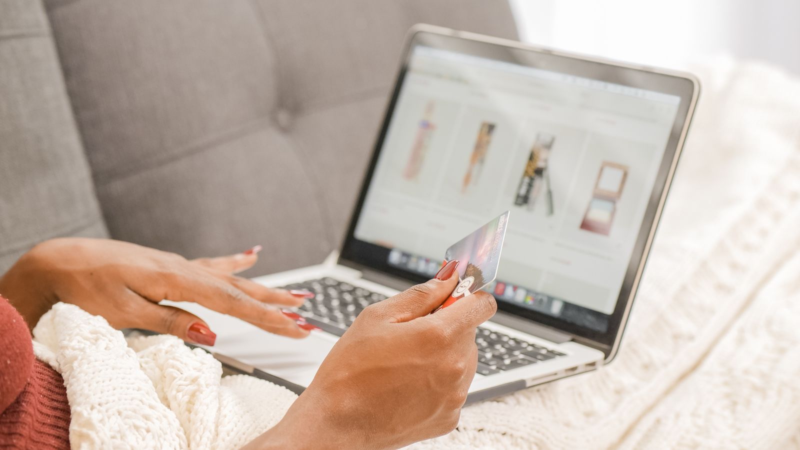 A shopper using a laptop and credit card at home.