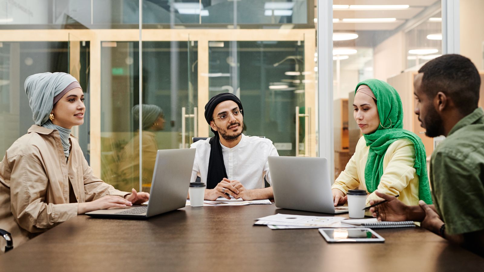 Coworkers using digital devices during a discussion.