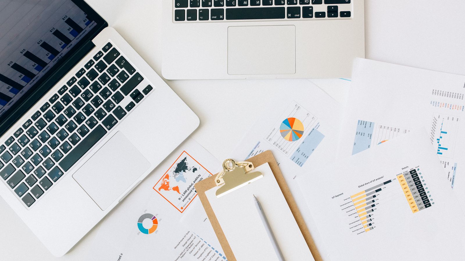 Laptops and business reports spread across a meeting table.