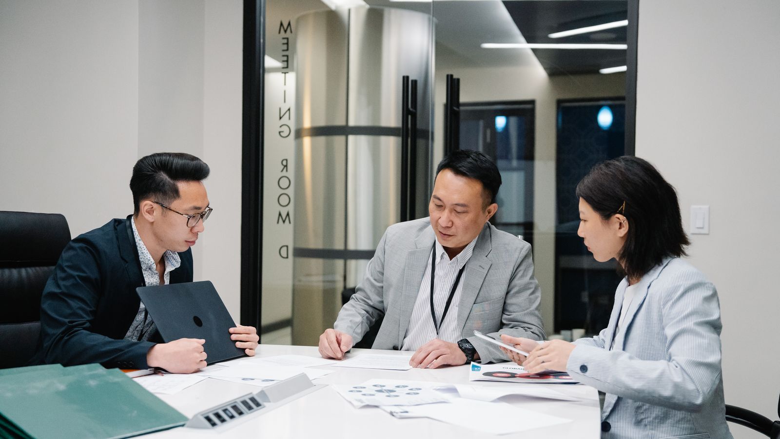 Three professionals collaborating during a meeting.
