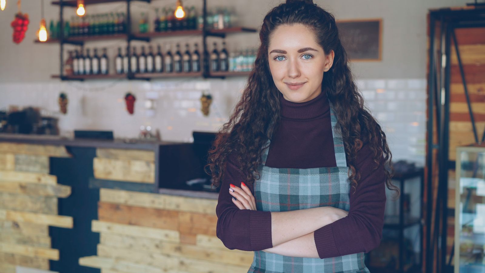 A café owner standing inside a coffee shop.