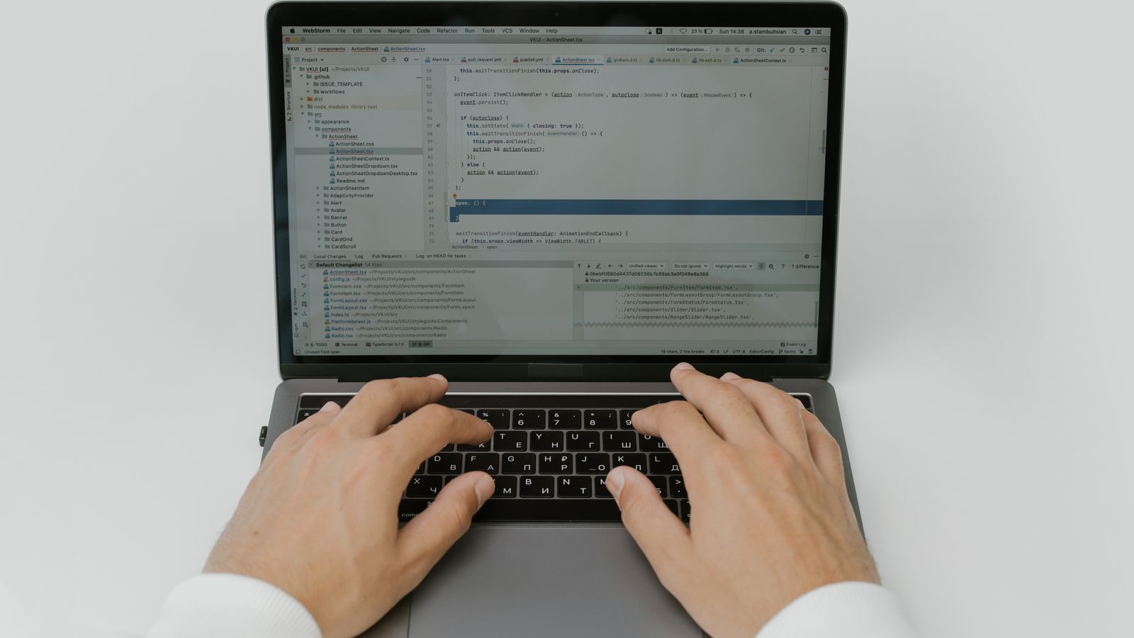 Hands typing code on a laptop keyboard.