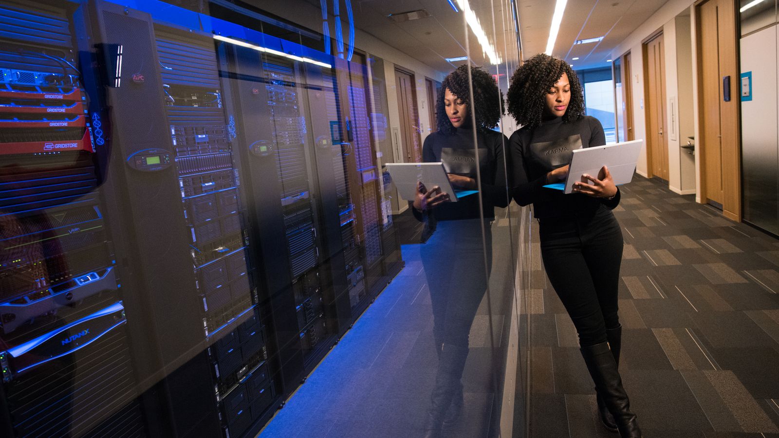 A professional using a laptop in a data centre.