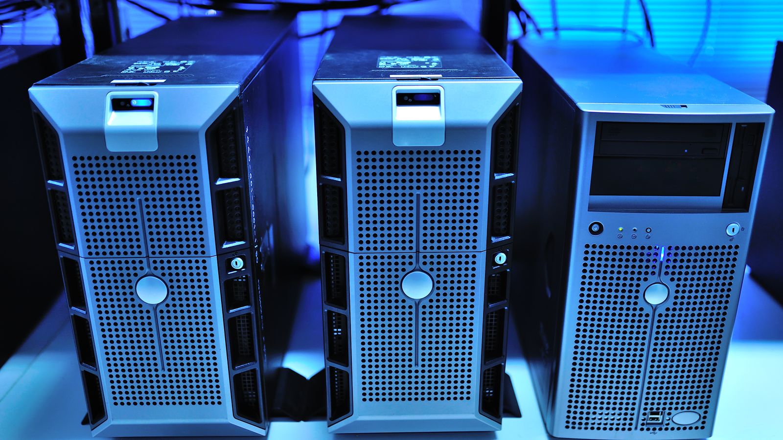 Computer towers in a blue-lit server room.