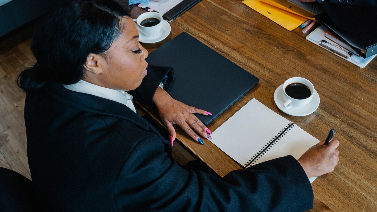 A professional taking notes during a meeting.