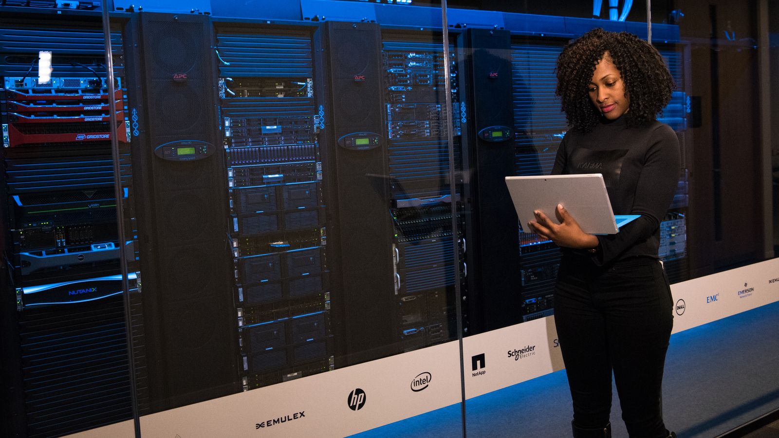 An engineer working with a laptop beside server equipment.